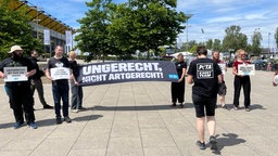 Demonstration für den Tierschutz, zwei Frauen tragen ein Banner mit der Aufschrift "Ungerecht, nicht artgerecht!"