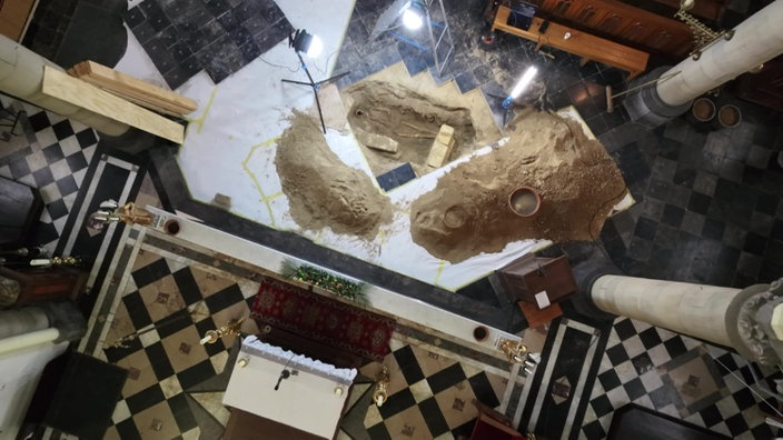 Ein Kirchen-Boden, in dem ein Loch für archäologische Ausgrabungen ist.