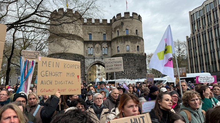 Mehrere Personen demonstrieren gegen sexualisierte Gewalt in Köln. 