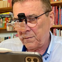 Dieter Holthaus sitzt mit einer speziellen Brille vor dem Laptop