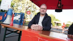 Dirk Vaas sitzt vor dem Werksgelände von Ford.