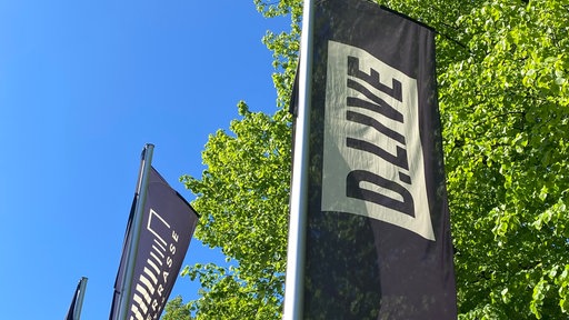 Schwarz-weiß Flagge von D.Live vor der Rheinterrasse in Düsseldorf
