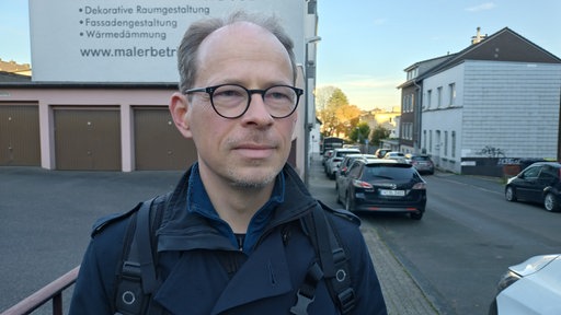 Mann mit Brille steht in Straße