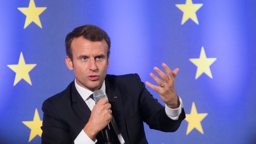Emmanuel Macron hält eine Rede vor einer Europaflagge