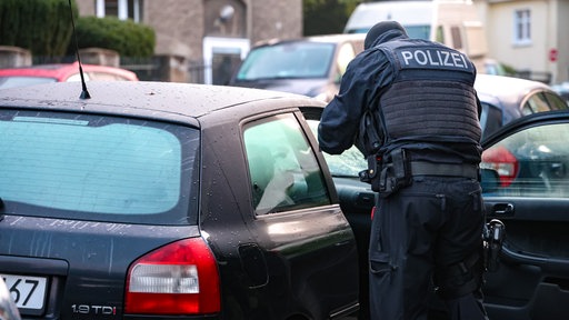 Polizist fotografiert ins offene Auto