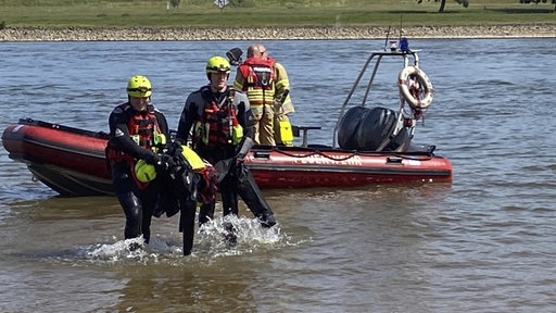 Strömungsretter ziehen hilflose Person aus dem Rhein