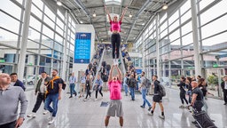 Ein Mann balanciert eine Frau auf seinen Schultern auf der Fibo 