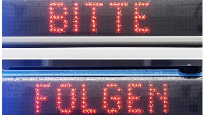 Symbolbild: "Bitte Folgen" Leuchttafel von der Polizei