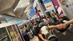 Hunderte Passaguere warten am Samstag am Flughafen Köln/Bonn