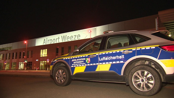 Ein Auto der Luftsicherheit vor einem Gebäude des Flughafens Weeze