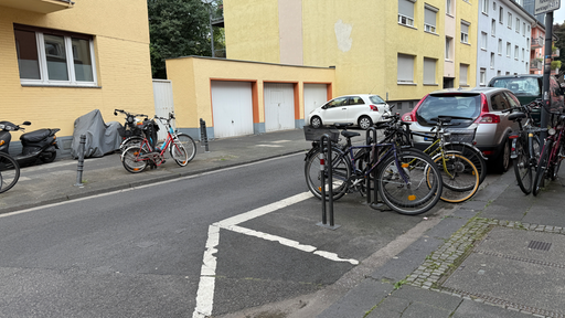 An einer Kreuzung stehen Poller und Fahrradständer.
