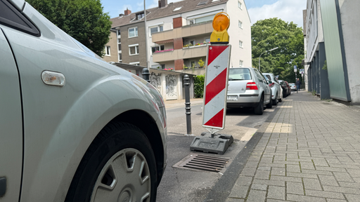 Eine Warnbarke steht zwischen Autos, wo vorher ein Parkautomat stand.