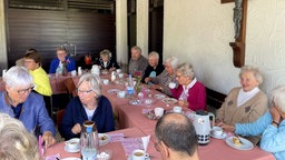 Eine Kafeetafel mit vielen glücklichen Personen