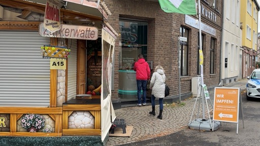 Der Eingang zu den Impfräumen neben einem Zuckerwattestand