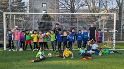 Ein Jugendteam des ISC AlHilal Bonn und deren Trainer stehen auf dem Fußballplatz im Pennenfeld.