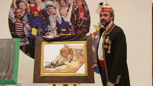 Zugleiter Marc Michelske steht neben eingerahmtem Motiv.