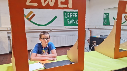 Zu sehen ist Bjarne (11), der eine Bankausbildung macht.