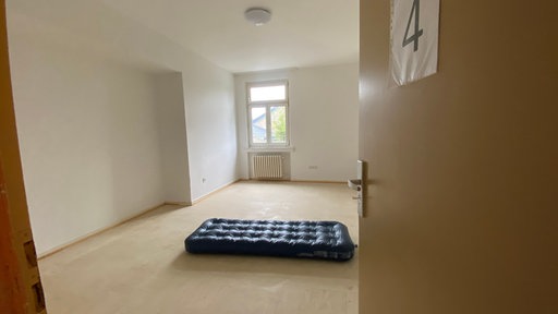Luftmatratze liegt mitten in leerem Raum