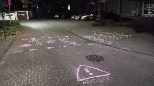 Auf eine Straße wurde mit Kreide ein Zebrastreifen symbolisiert. Zudem wurde auf die Straße "Stadt für alle", "Schulstart braucht Zebras" und "Achtung" geschrieben 