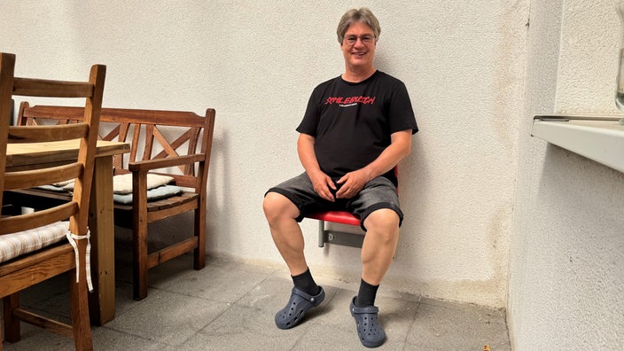 Bayer-04-Fan sitzt stolz auf seiner Sitzschale aus dem Stadion