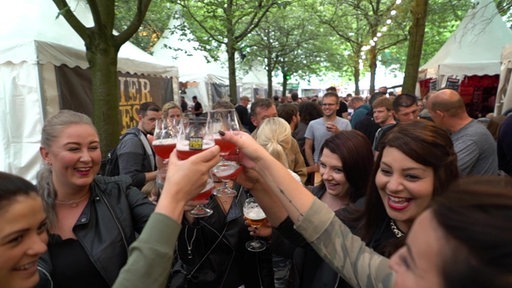 Fröhliche Menschen stoßen mit Biergläsern an