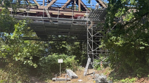 Brücke, ein unfertiges Gerüst und Baumaterialien