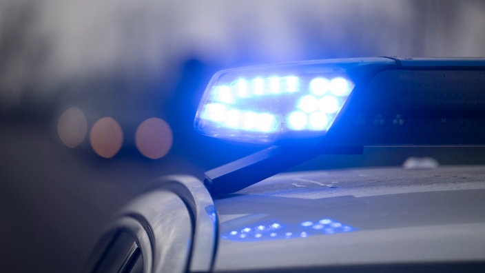 Ein Blaulicht blinkt an einem Einsatzfahrzeug der Polizei.