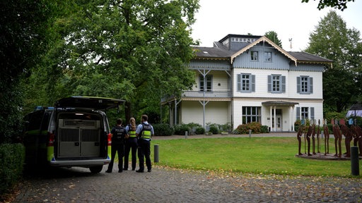 Einsatzkräfte der Polizei Köln stehen vor der Villa Wuppermann in Leverkusen.