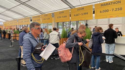 Menschen stehen Schlange für den Marathon in Bonn