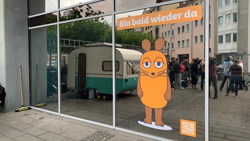 An der Glasfront klebt jetzt ein Bild von der Maus und ein Schriftzug mit "Bin bald wieder da"