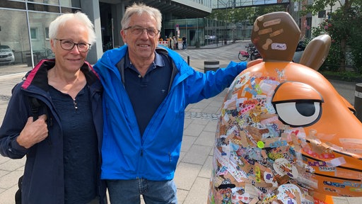 Älteres Ehepaar posiert neben der Maus für ein Foto