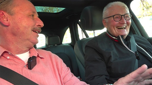Zwei lachende Senioren im Auto