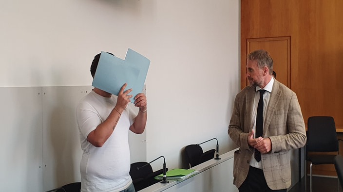 Links der Angeklagte und rechts der Verteidiger im Gerichtssaal