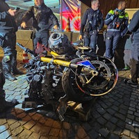 Polizisten und andere Personen stehen um ein demoliertes Motorrad