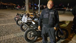 Polizist steht vor Motorrädern