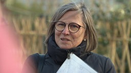 Eine Frau spricht in die Richtung zu jemand anderen. 
