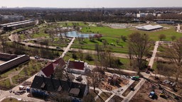 Das Gelände der Landesgartenschau von oben: Riesige Wiese, Bäume ringsherum und ein kleiner See