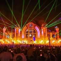 Ein großes Publikum steht vor der Parookaville-Bühne und feiern. Es ist bereits Nacht und Laser-und Feuerstrahler erhellen die Bühne.