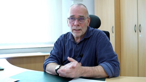 Martin Süsterhenn sitzt an einem Schreibtisch
