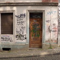 Eine verschmierte und mit Brettern verschlossene Hausfassade