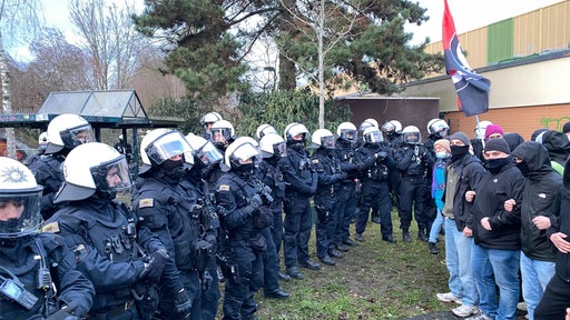 Gruppe von Plozisten gegenüber von Demonstranten