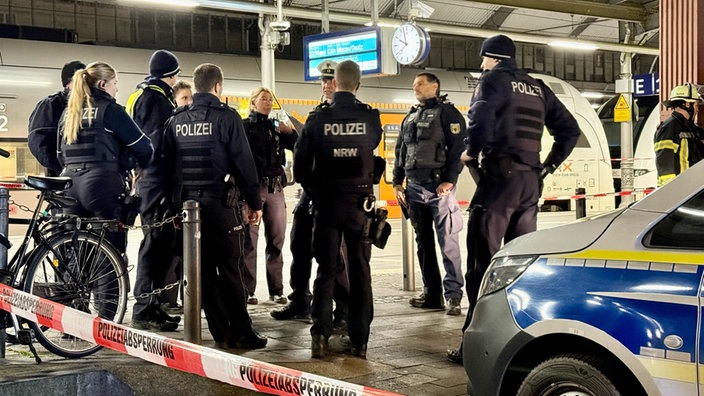 Polizisten stehen vor dem abgesperrten Bonner Hauptbahnhof.