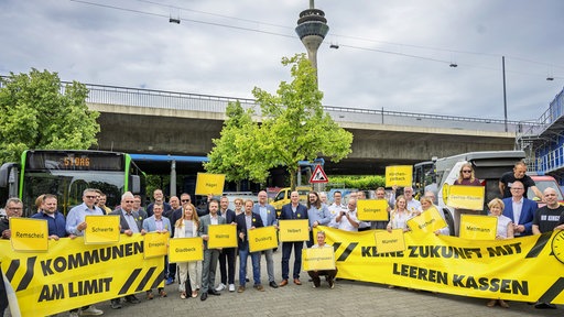 Vertreter der NRW-Kommunen stehen auf dem Johannes-Rau-Platz in Düsseldorf.