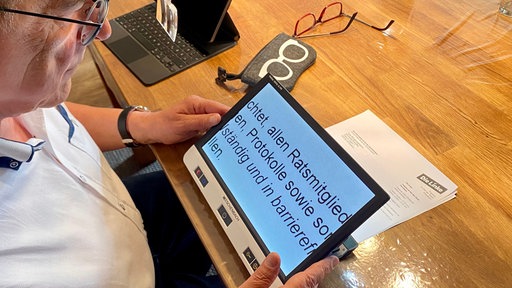 Dieter Holthaus liest am Laptop einen Text in großer Schrift