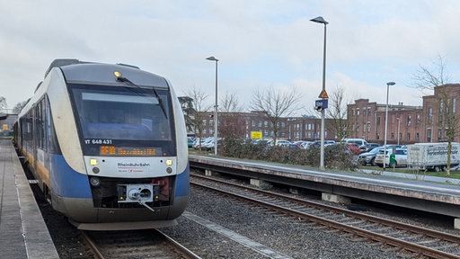 Ein blau-silberner Zug steht auf einem Gleis im Bahnhof Kleve
