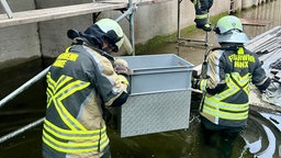 Feuerwehrleute waten durch hüfthohes Wasser im Schleusenbecken