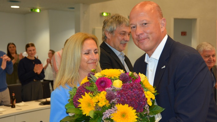 Landrat Frank Rock übergibt seinen Blumenstrauss an seine Frau
