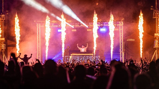 Bühnenshow mit Flammen und Publikum im Vordergrund