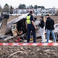 Einsatzkräfte stehen um das abgestürtze Flugzeug auf einem Acker in Sankt Augustin