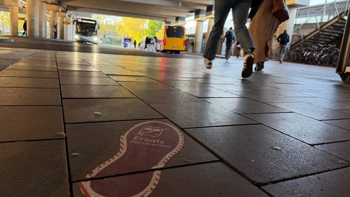 Ein Fußabtritt leitet am Bahnhof Siegburg am Boden in Richtung des Schienenersatzverkehrs
